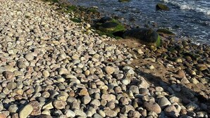 Una costa rocciosa con le onde che si infrangono sulle rocce.