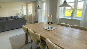 Un'area pranzo moderna con un tavolo in legno, sedie confortevoli e candele.
