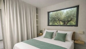 Un dormitorio moderno con una cama grande, una ventana con vista a árboles, una mesita de noche con una planta y una cortina.