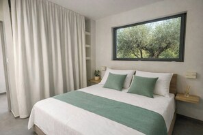 Ein modernes Schlafzimmer mit einem großen Bett, einem Fenster mit Blick auf Bäume, einem Nachttisch mit einer Pflanze und einem Vorhang.