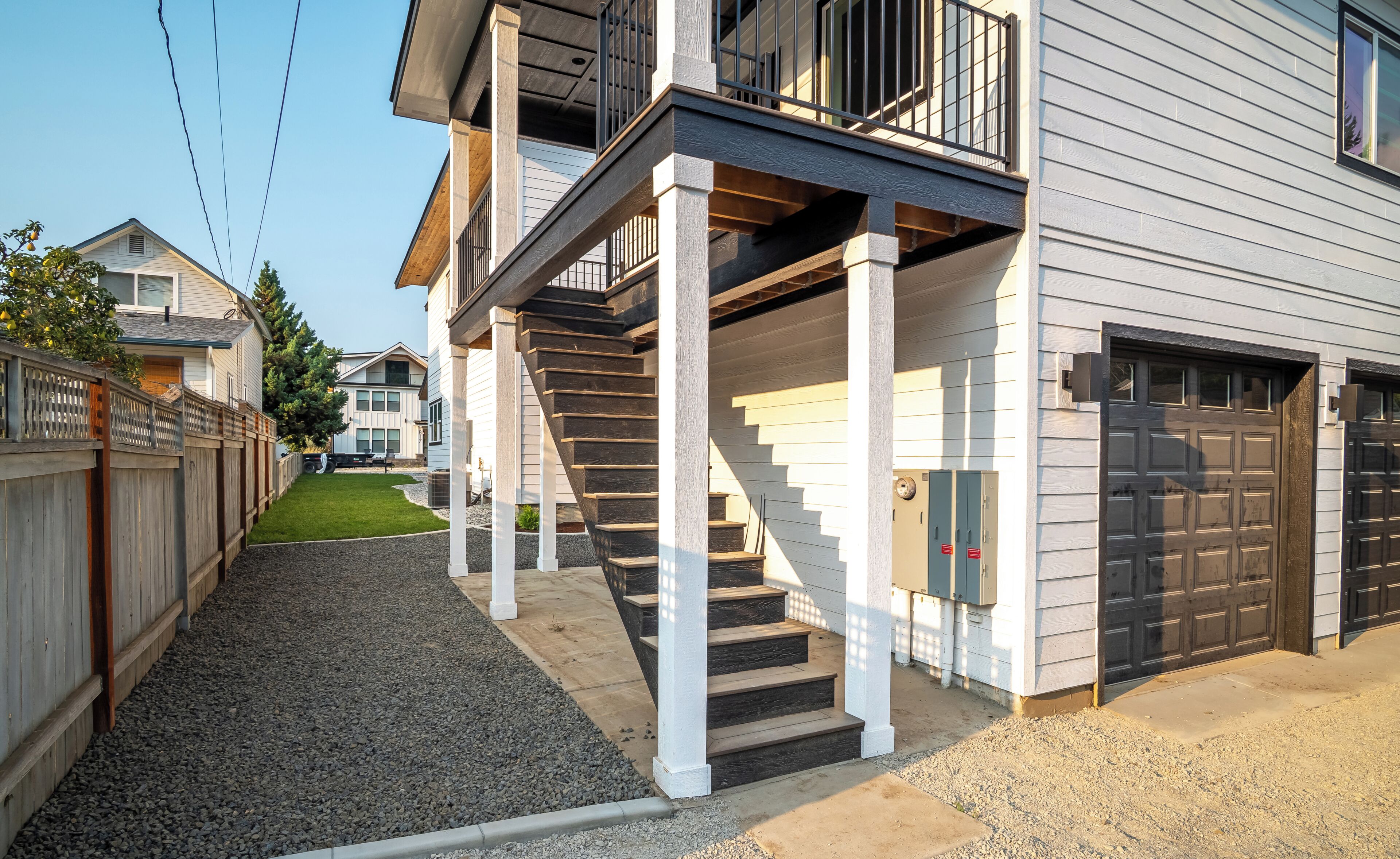 A residential property with a front yard, a staircase leading to a porch, and a garage door.