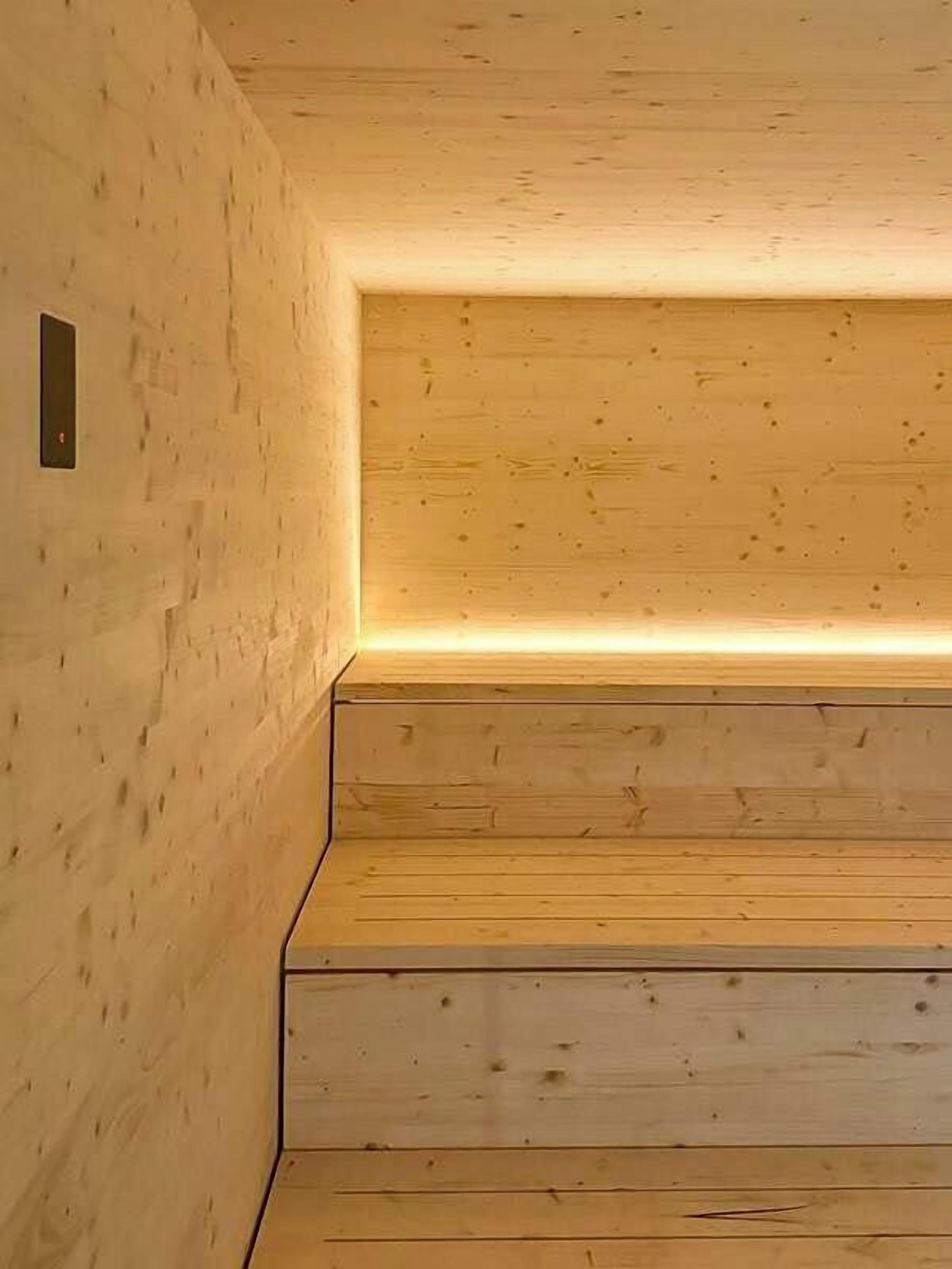 Un escalier en bois, doté d’une main courante illuminée, qui mène à un niveau supérieur.