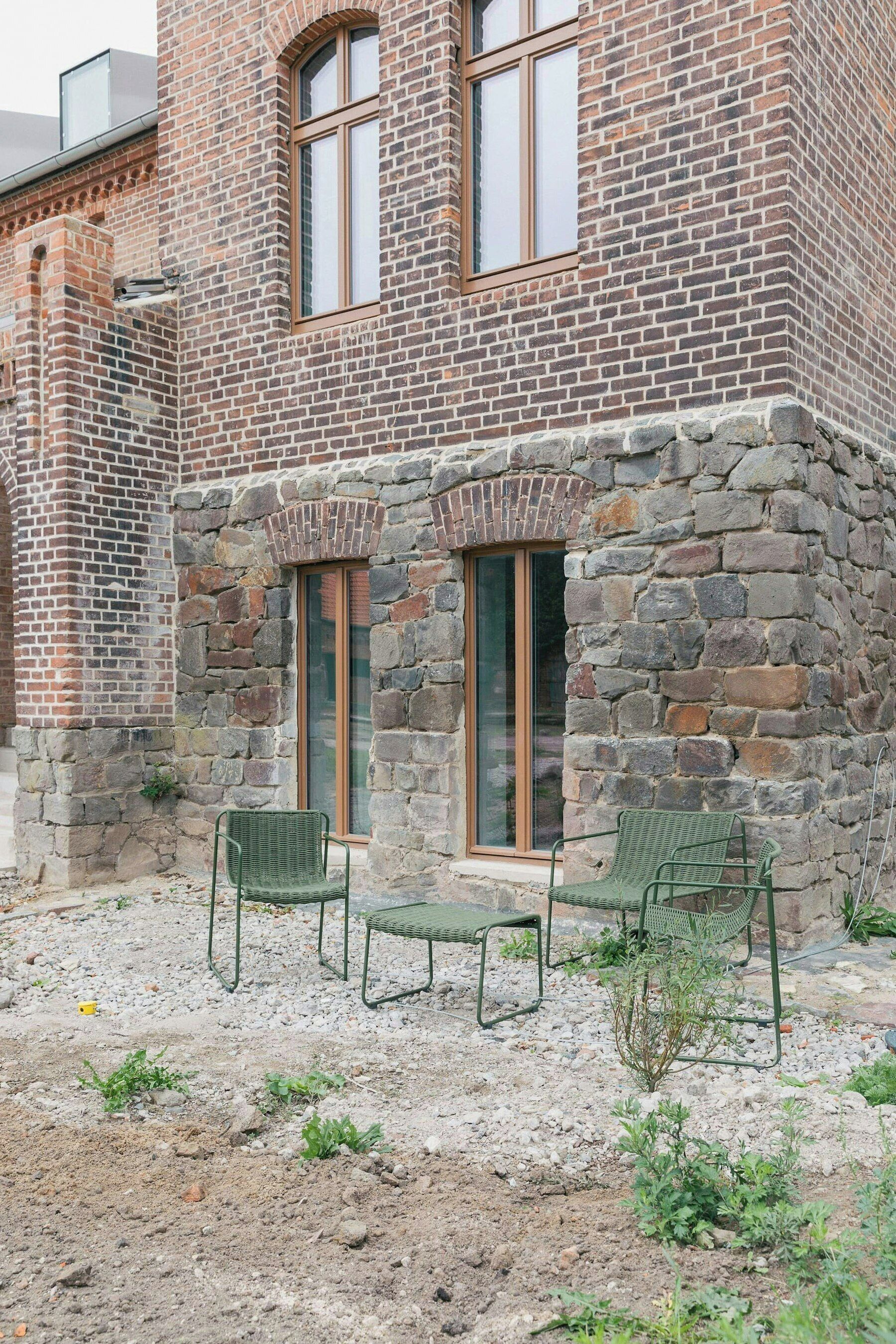 Un edificio de piedra con dos ventanas y fachada de ladrillo.