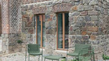 Un edificio de piedra con dos ventanas y fachada de ladrillo.