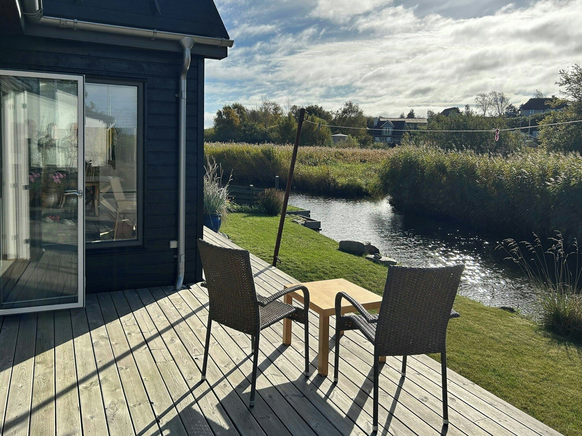 Una terrazza con sedie e un tavolo che si affaccia su un fiume.