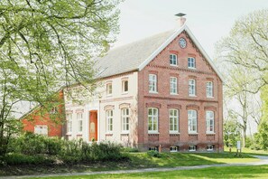 Ein großes Backsteinhaus mit vielen Fenstern und einem markanten Eingang.