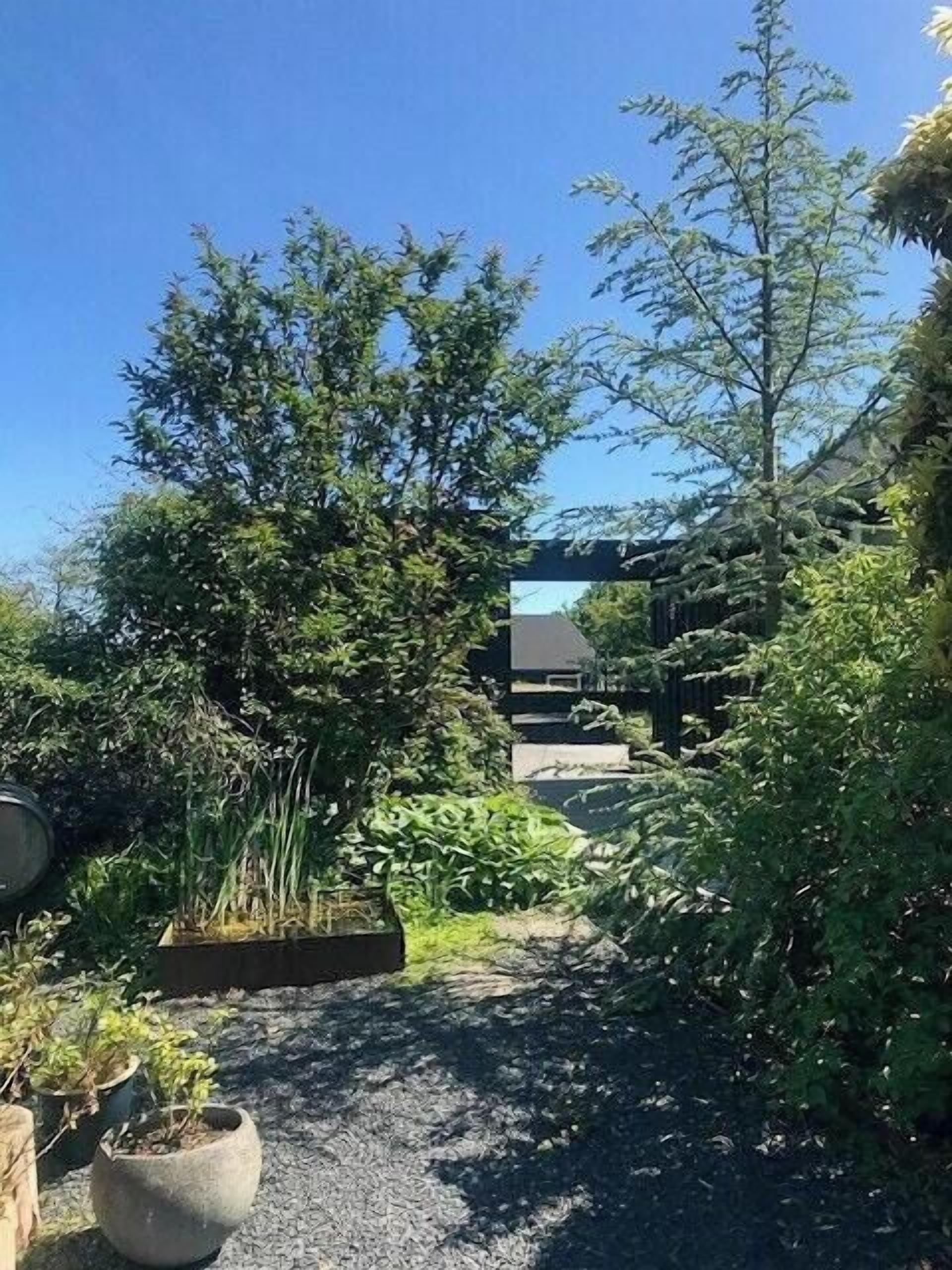 Un chemin de jardin menant à un bâtiment au design moderne.