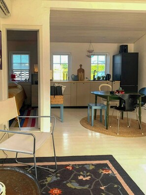Ein gemütlicher Wohnraum mit Küchenzeile, Essbereich und einem kleinen Schlafzimmer.
