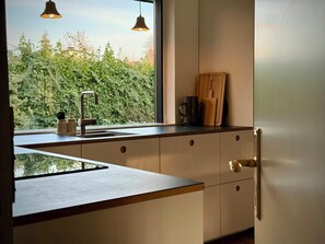 A modern kitchen with a window, a sink, and a refrigerator. - Design-led nature retreat, near Hornbæk beach (hornbæk)
