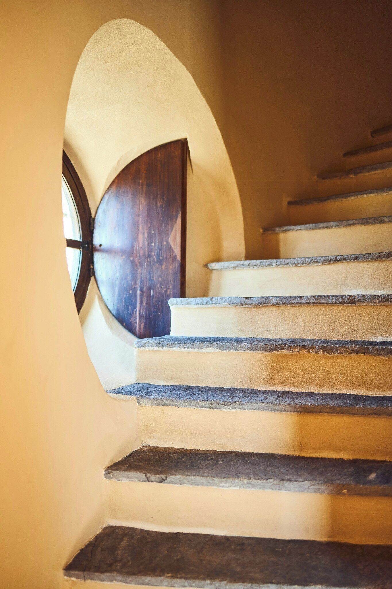 Eine Treppe mit Steinstufen und einer Holztür am Oberende.