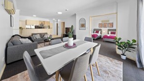 A modern apartment with a dining area, kitchen, living room, and two bedrooms.