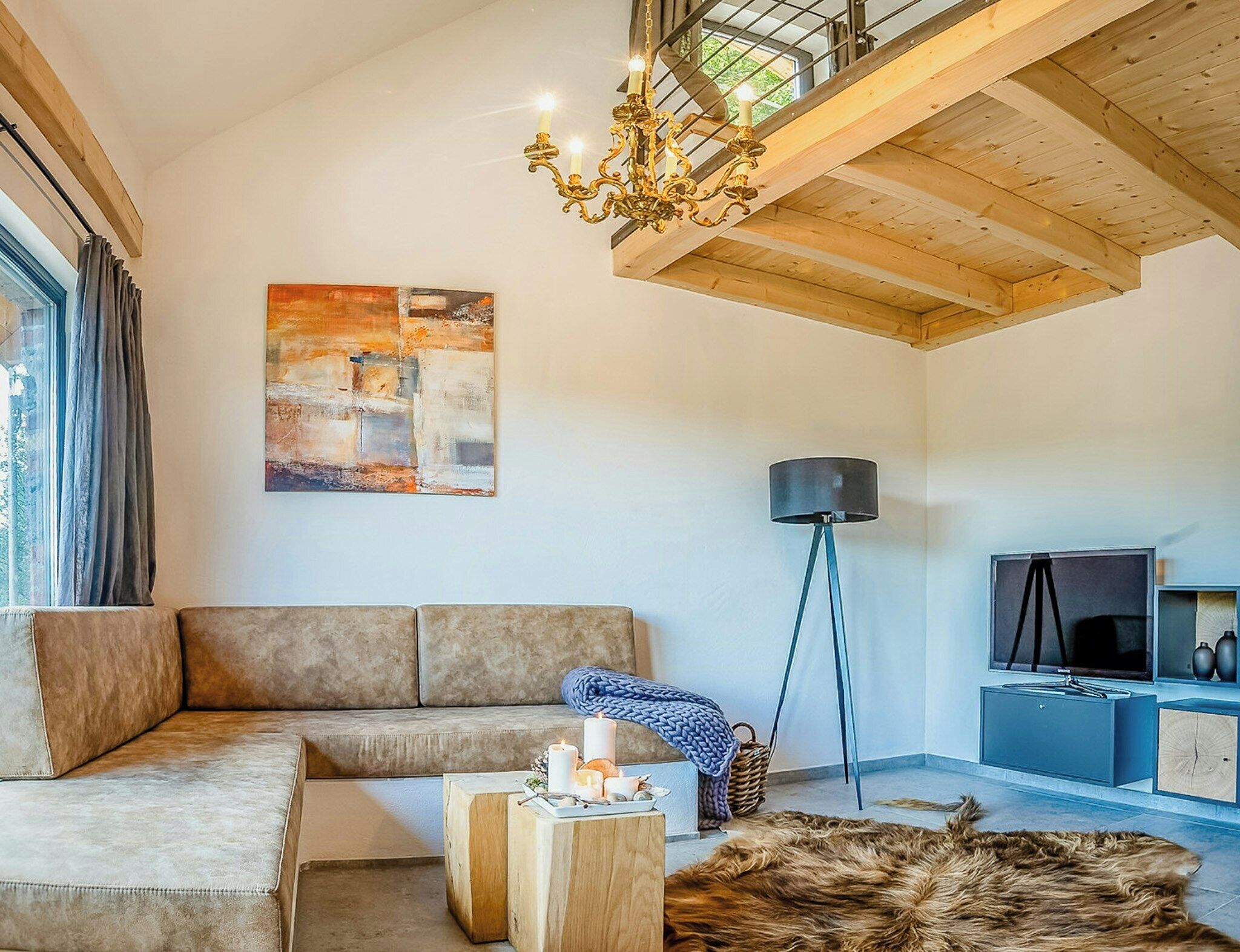Ein modernes Wohnzimmer mit Sofa, Couchtisch, einer Deckenleuchte, einem Gemälde, einer Stehlampe und einem Fernseher.