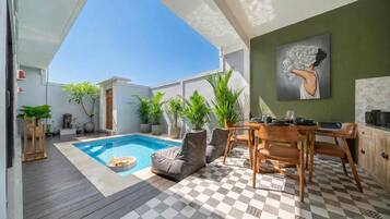 Eine moderne Außenpatio mit Pool, Sitzbereich und Essplatz.