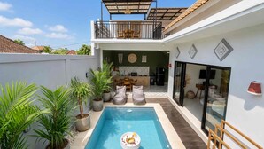 Propiedad residencial con piscina, balcón y zona de cocina.