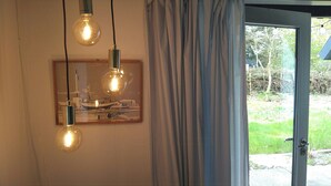Una habitación con una puerta, un ventanal y tres lámparas colgantes.