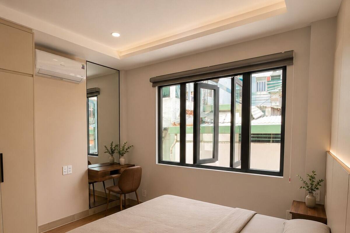 Ein Schlafzimmer mit Bett, Schreibtisch, Stuhl, einem Fenster mit Jalousien und einem Spiegel.