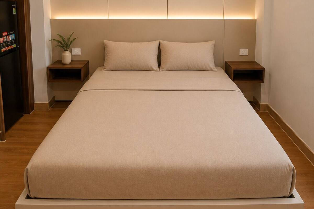 Ein modernes Schlafzimmer mit einem großen Bett, Holznachttischen und Einbauleuchten an der Decke.