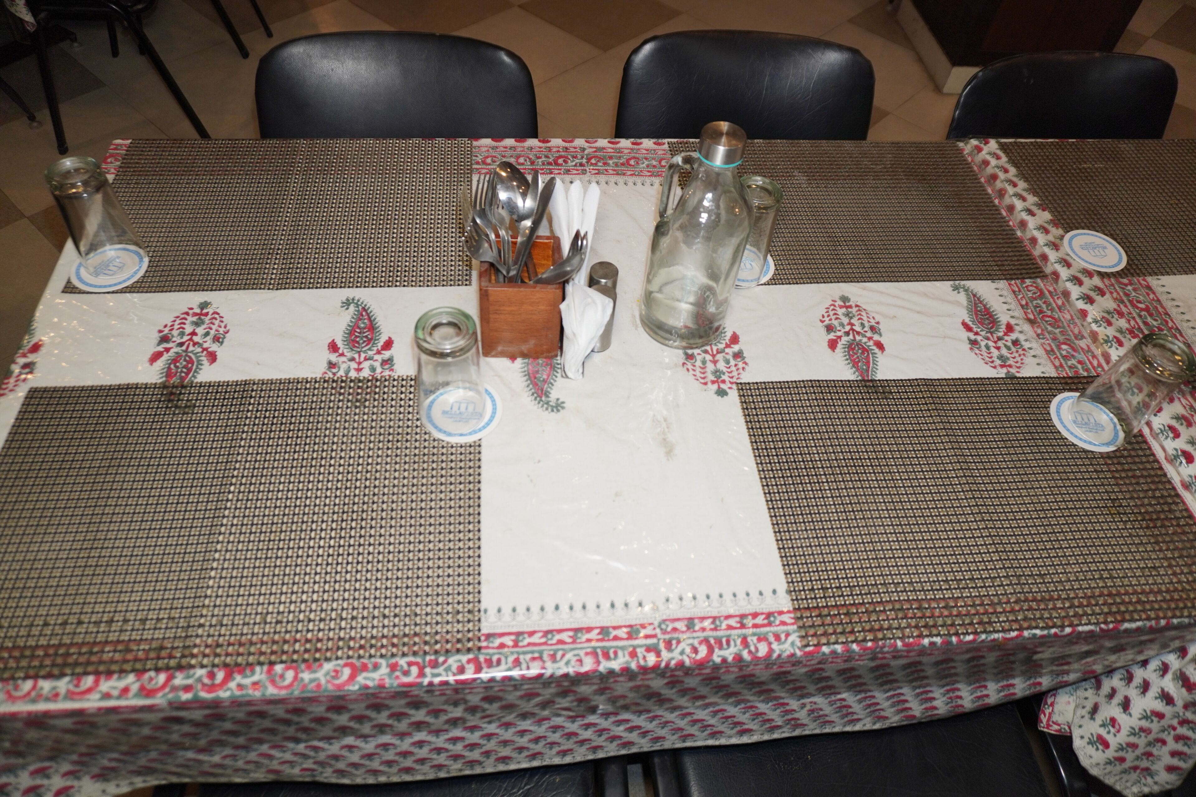 A dining table set with placemats, cutlery, and glassware.