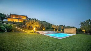 A modern house with a swimming pool, surrounded by a well-maintained lawn and a hill. - House with pool and citrus grove near Noto (Noto)
