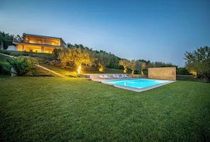 A modern house with a swimming pool, surrounded by a well-maintained lawn and a hill. - House with pool and citrus grove near Noto (Noto)