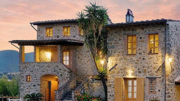 A stone building with a staircase, outdoor seating, and a view of the mountains. - Large country house near Lucca with private pool (San Gennaro)