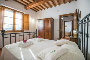 Ein Schlafzimmer mit einem Bett, einem Holzschrank und einem Fenster mit Vorhängen.