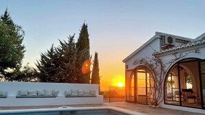 Una piscina amb una paret blanca i una zona de terrassa.