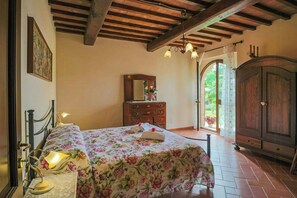 Ein Schlafzimmer mit Bett, Kommode, Spiegel und einer Deckenleuchte.