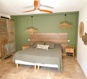 A bedroom with a bed, a ceiling fan, a green wall, and a rustic door. - Provençal farmhouse in preserved natural setting (Fréjus)