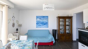 Una habitación con cama, armario, escritorio y mesa de comedor.