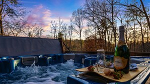 Ein Whirlpool mit einer Flasche Korbel Wein, einem Glas und Snacks.