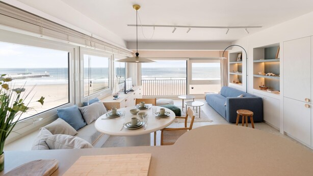 Ein modernes Interieur mit Essbereich, Sofa und Meerblick.