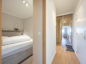 Ein Schlafzimmer mit einem Bett, einem Nachttisch und einer kleinen Ablage mit einem dekorativen Gegenstand.