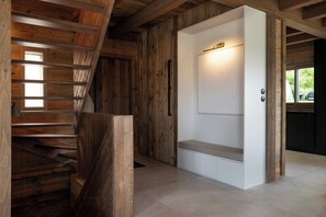 A wooden interior with a staircase, a white door, and a bench. - Family chalet with Vosges mountain views in Gérardmer (Gérardmer)