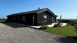 Ein modernes, zweistöckiges Haus mit gepflegtem Rasen und einem Schotterweg.