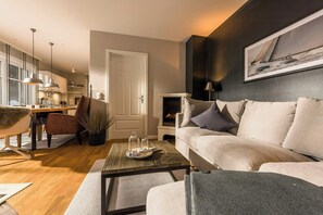 Ein modernes Wohnzimmer mit einer Couch, einem Couchtisch und einem Kamin.