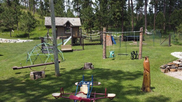 En lekplats med gungor, en rutschkana och en klätterställning.