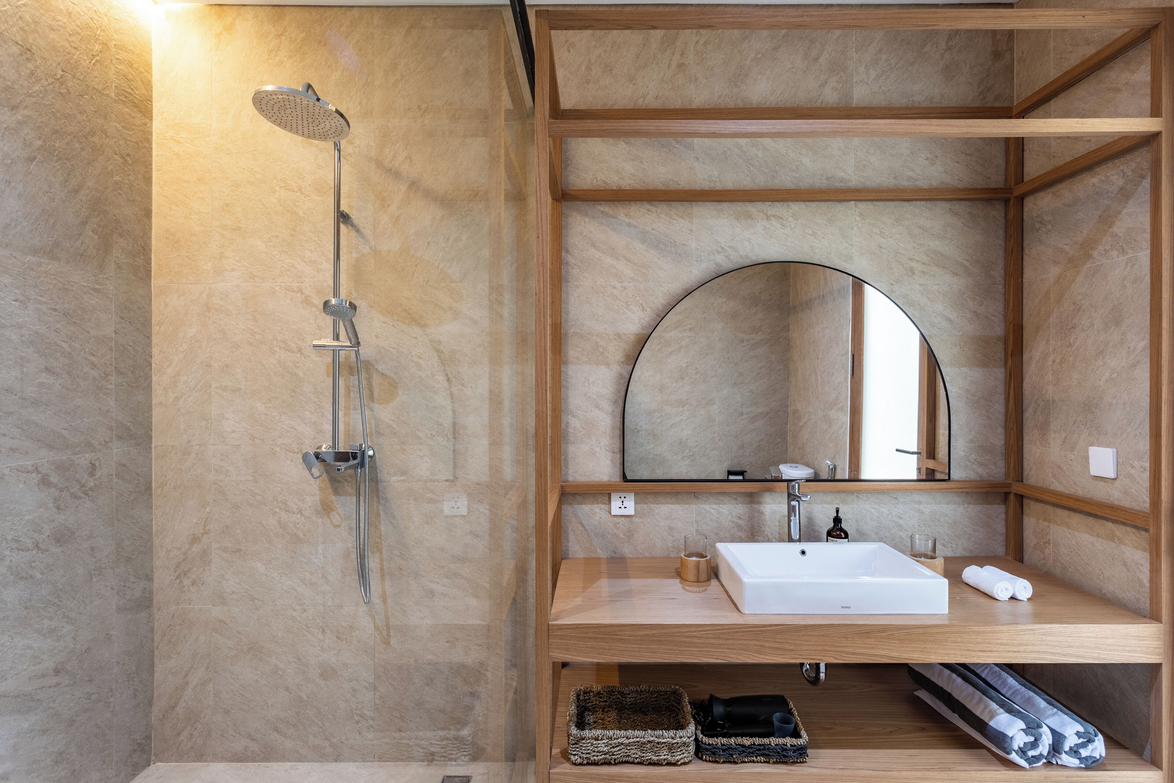 Ein modernes Badezimmer mit Dusche, Waschbecken und Spiegel.
