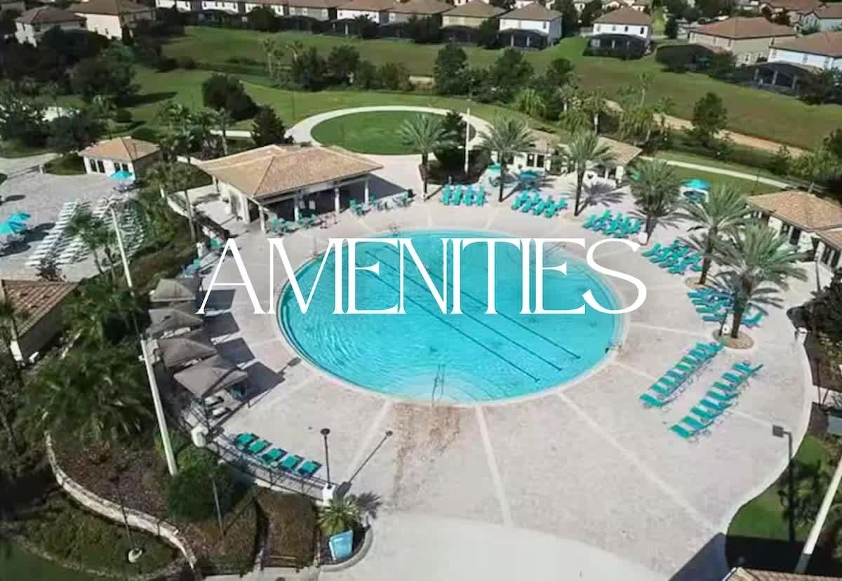 An aerial view of a residential area with a swimming pool surrounded by lounge chairs and palm trees.