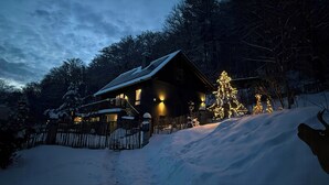 Eine Holzhütte mit Veranda und verschneiter Landschaft.