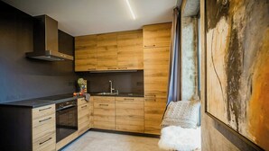 Eine moderne Küche mit Holzschränken, einem eingebauten Ofen und einem großen Fenster mit Blick.