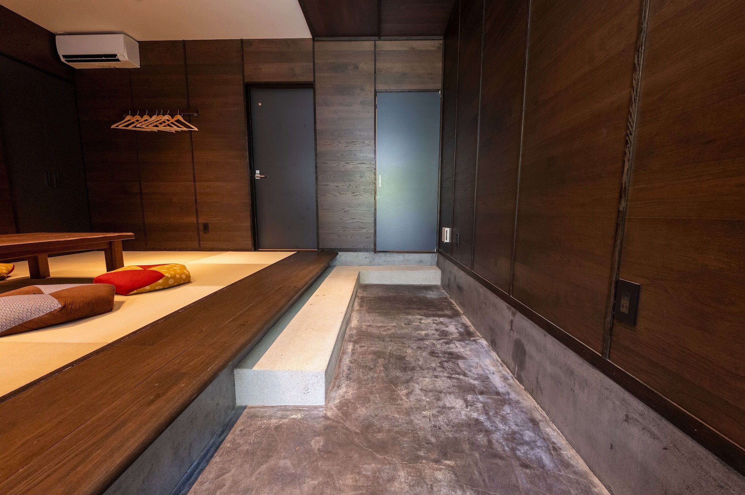 Ein modernes Interieur mit einer Bank, einer Holzwand und einer Tür.