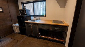 A compact kitchen with a sink, a microwave, and a small refrigerator.