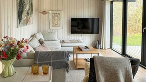 Ein modernes Wohnzimmer mit Sofa, Couchtisch und Fernseher.