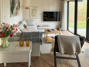 Ein modernes Wohnzimmer mit Sofa, Couchtisch und Fernseher.