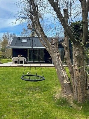 Ein modernes Haus mit Schaukel im Garten.