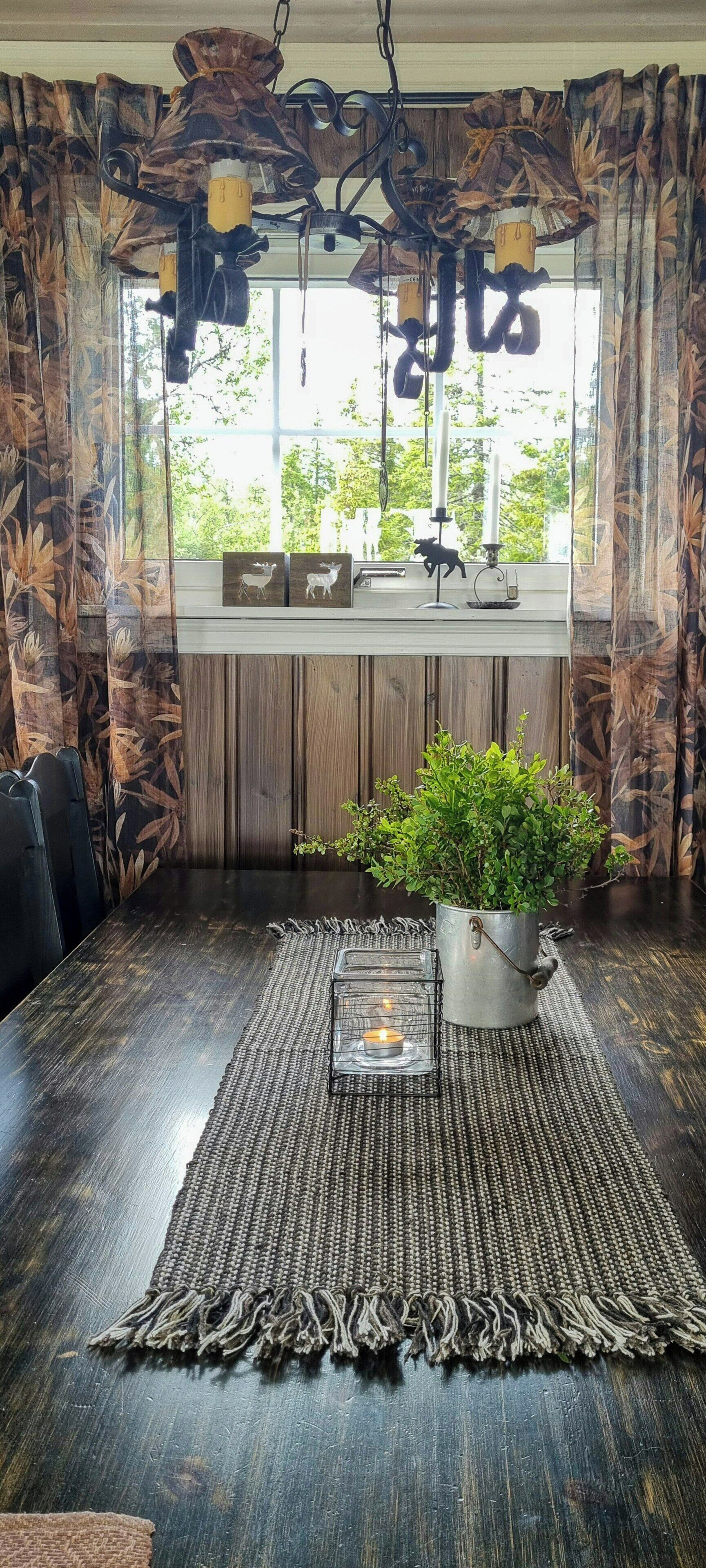 A dining area with a wooden table, a potted plant, and a candle holder.