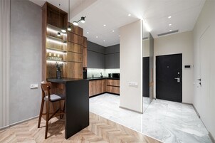 Een moderne keuken met een bar, houten kastjes en een visgraatvloer.