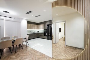 Een moderne keuken met een centraal eiland, een eethoek met een witte tafel en stoelen, en een vloer met een visgraatmotief.