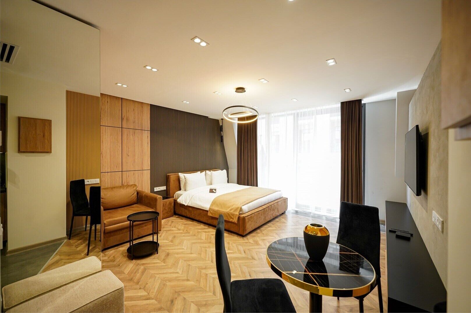 Une chambre d’hôtel moderne équipée d’un lit, d’un coin salon, d’une télévision et offrant une vue sur la ville.